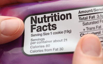 Reading a nutritional facts on cookies packaging. Close-up.